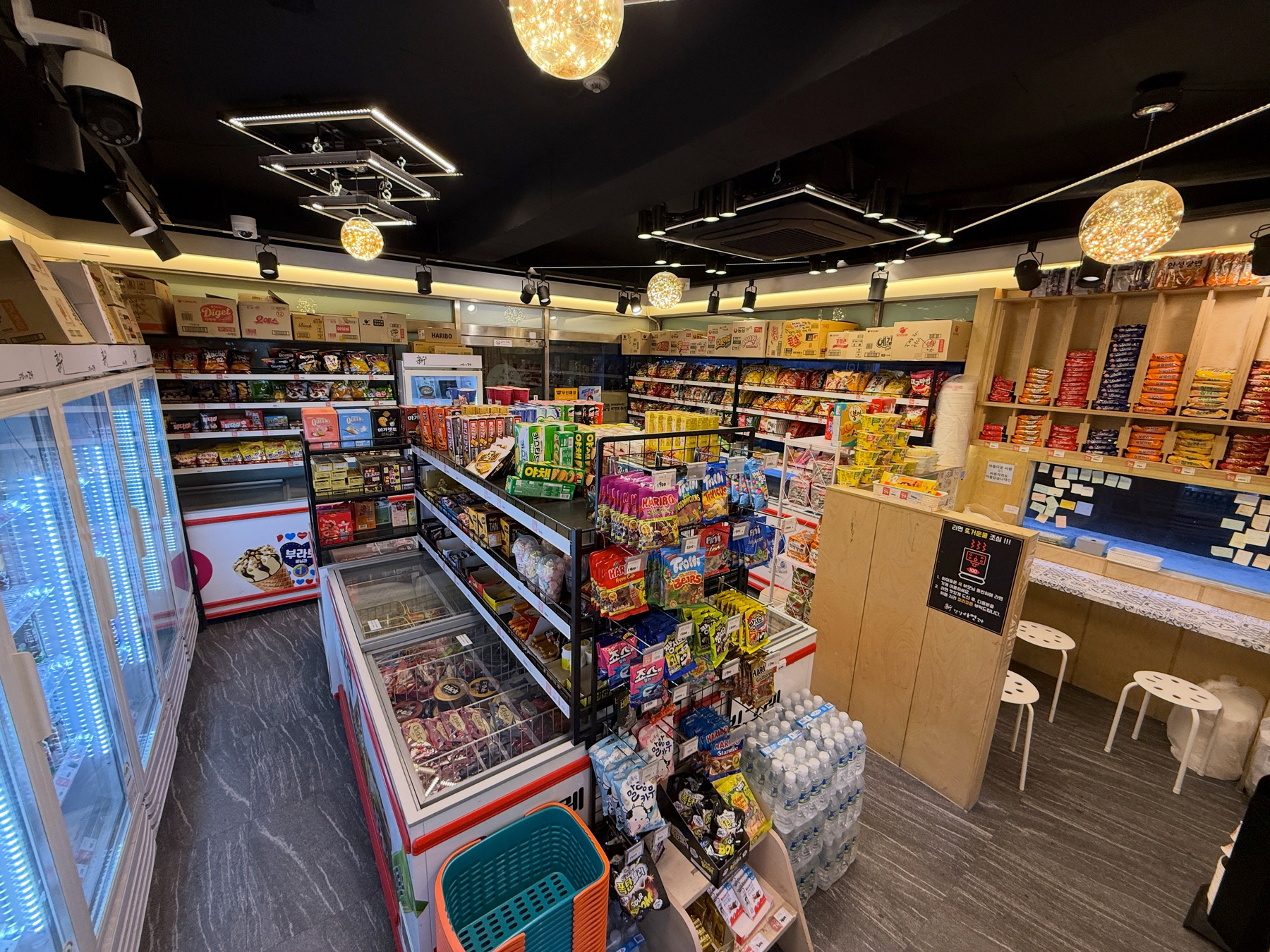 Auto-generated description: A brightly lit convenience store features well-stocked shelves with snacks, drinks, and other grocery items.